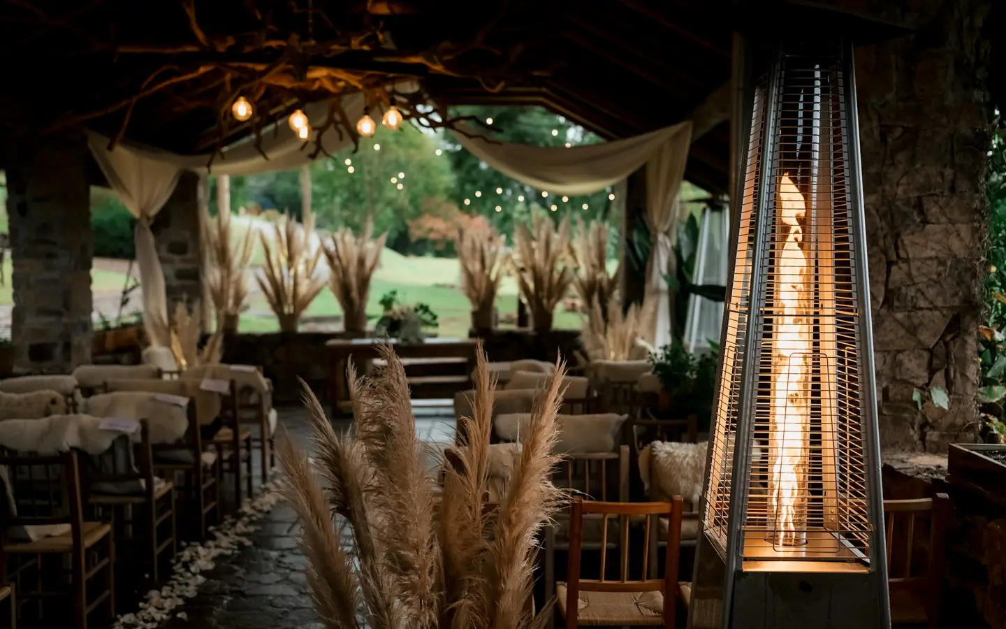 An outdoor event area set with string lights and lounge seating at dusk